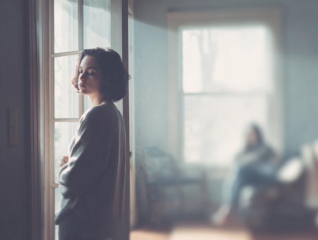 iemand die thuis een raam opent om sigarettenrook te vermijden